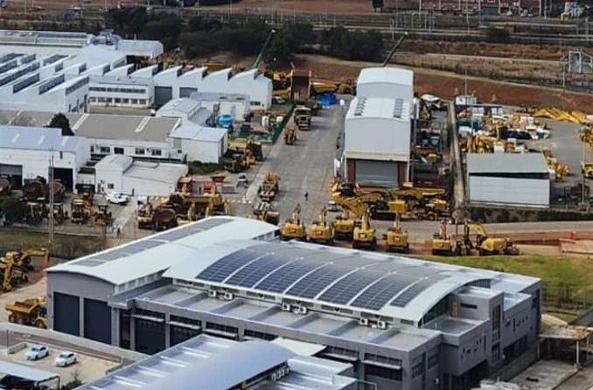 Rooftop solar on Barloworld's building in Isando, with earthmoving machines in the yard behind